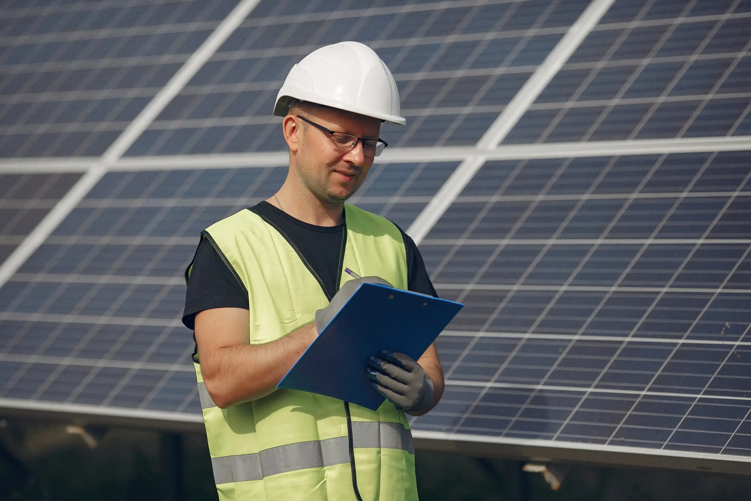 man-with-white-helmet-near-solar-panel-min-scaled